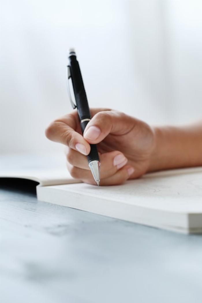 main qui écrit avec stylo