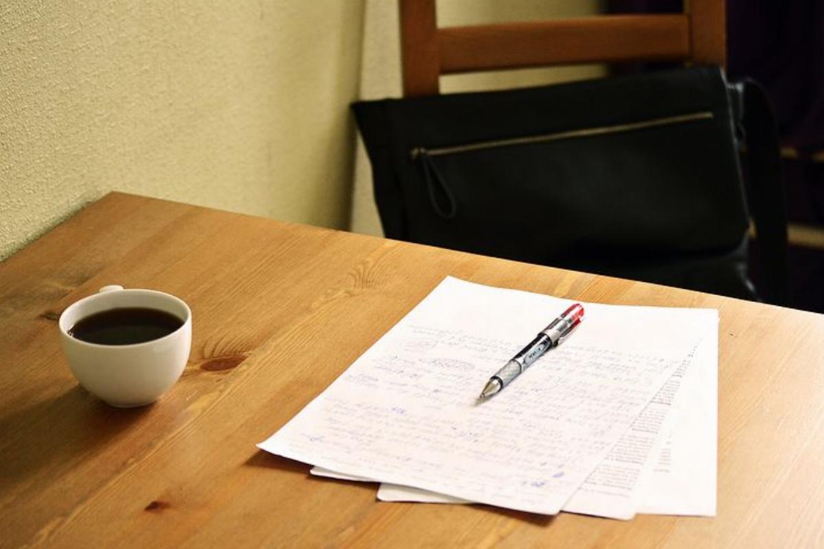 papier écrit sur une table avec tasse à café