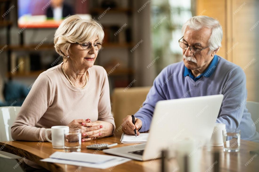 Couple de personnes âgées calculant la valeur de leur patrimoine en vue de leur succession